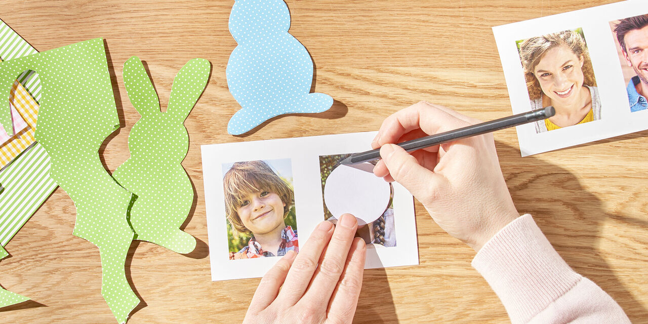 Dve roki s predlogo narišeta krog okoli glave družinskega člana. Zraven so natisnjene instant fotografije in iz papirja izrezani velikonočni zajčki.